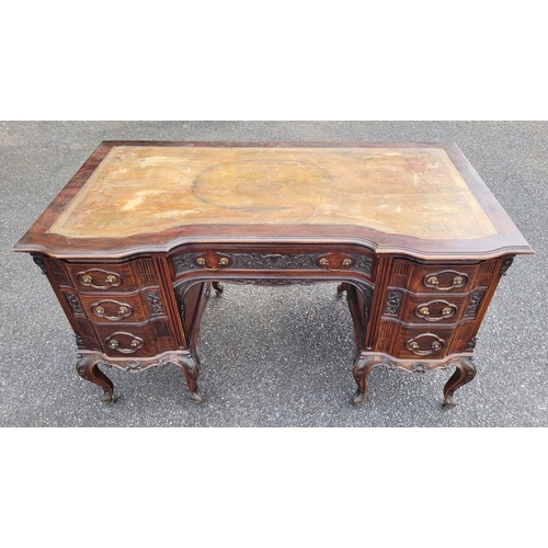 360 - AN EARLY 20TH CENTURY 7 DRAWER LEATHER TOPPED DESK, the top serpentine in shape with inset tooled le... 