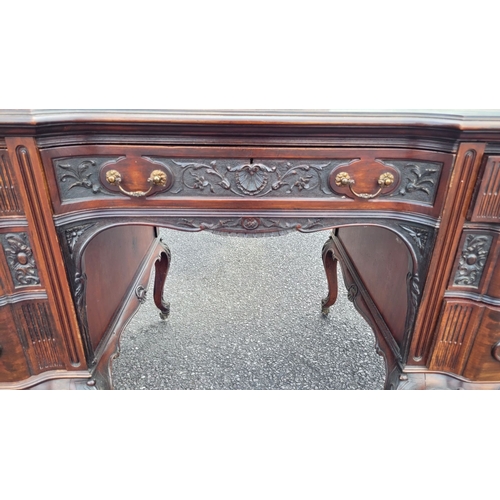 360 - AN EARLY 20TH CENTURY 7 DRAWER LEATHER TOPPED DESK, the top serpentine in shape with inset tooled le... 