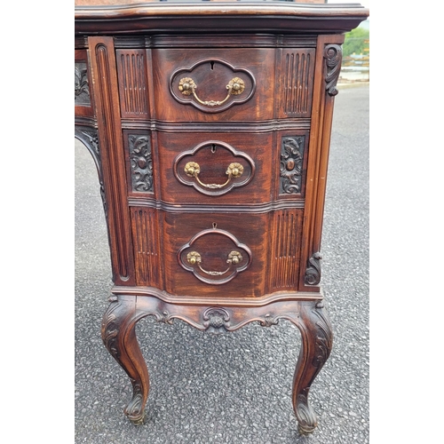 360 - AN EARLY 20TH CENTURY 7 DRAWER LEATHER TOPPED DESK, the top serpentine in shape with inset tooled le... 