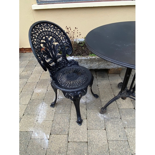 37 - A GOOD CAST ALLOY GARDEN/PATIO SET, to include two painted black cast alloy chairs with decorative o... 