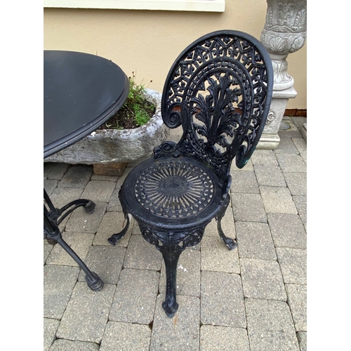 37 - A GOOD CAST ALLOY GARDEN/PATIO SET, to include two painted black cast alloy chairs with decorative o... 