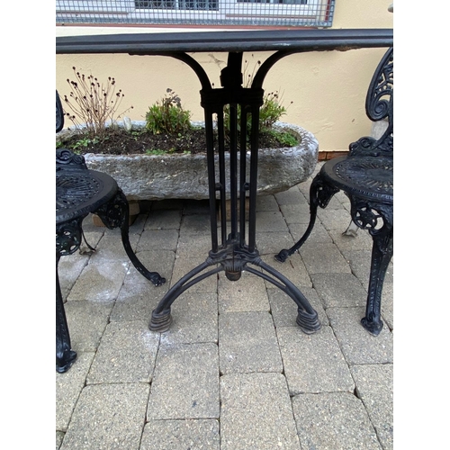 37 - A GOOD CAST ALLOY GARDEN/PATIO SET, to include two painted black cast alloy chairs with decorative o... 