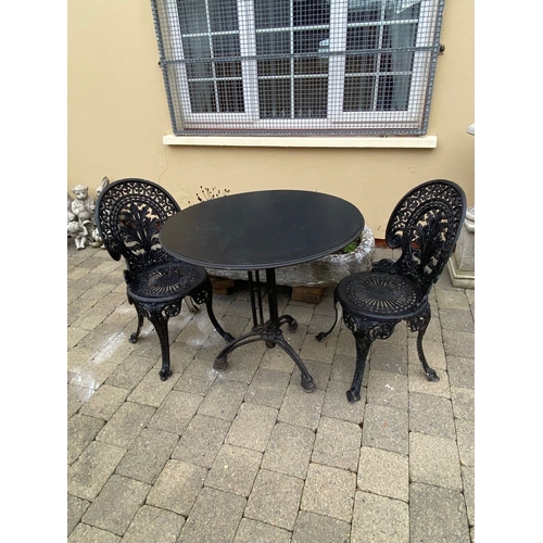 37 - A GOOD CAST ALLOY GARDEN/PATIO SET, to include two painted black cast alloy chairs with decorative o... 