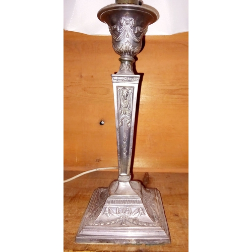 43 - AN EARLY 20TH CENTURY SILVER PLATED TABLE LAMP of tapered form, decorated with ribbon and foliage de... 