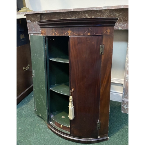 52 - A GEORGIAN BOW FRONTED HANGING CORNER CABINET, with a graduated pediment top, over a row of inlaid u... 