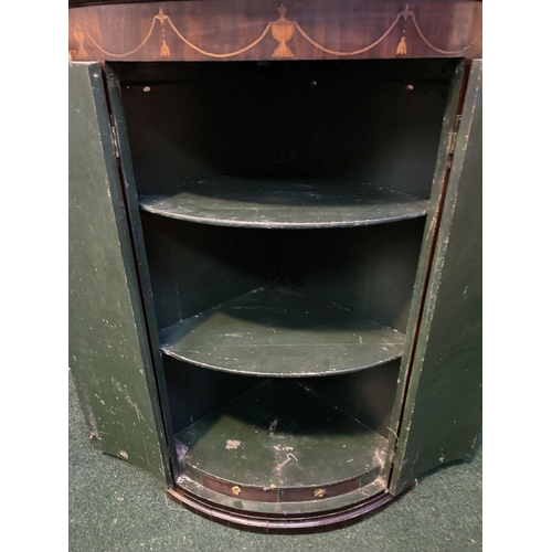 52 - A GEORGIAN BOW FRONTED HANGING CORNER CABINET, with a graduated pediment top, over a row of inlaid u... 