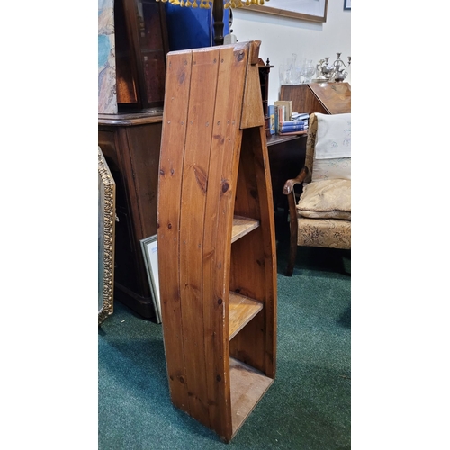 57 - A LOVELY PINE BOAT-SHAPED OPEN FLOOR BOOKCASE OR DISPLAY CABINET, of graduated form; having three op... 