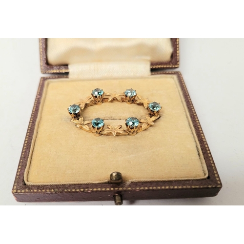 6 - A CASED 9CT YELLOW GOLD & TOPAZ BLUE GEMSTONE SET BROOCH, the brooch decorated with floral design an... 