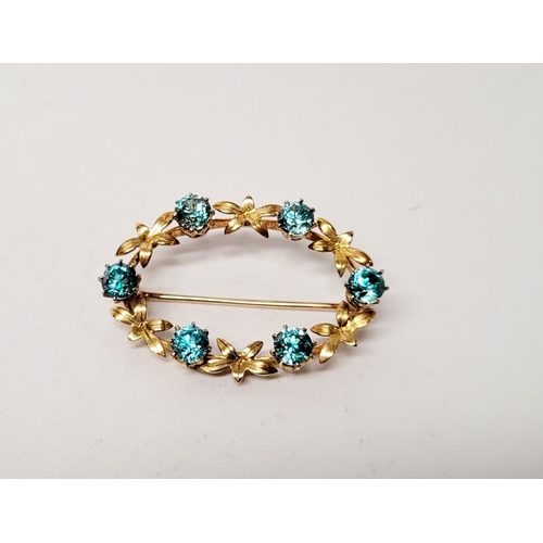 6 - A CASED 9CT YELLOW GOLD & TOPAZ BLUE GEMSTONE SET BROOCH, the brooch decorated with floral design an... 