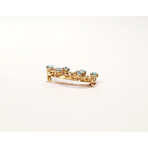 6 - A CASED 9CT YELLOW GOLD & TOPAZ BLUE GEMSTONE SET BROOCH, the brooch decorated with floral design an... 