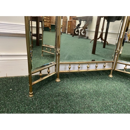 63 - A 19TH CENTURY BRASS THREE PANEL MIRRORED FIRESCREEN, with arched mirrors, ornate handle to central ... 