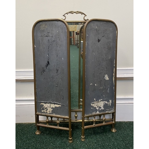 63 - A 19TH CENTURY BRASS THREE PANEL MIRRORED FIRESCREEN, with arched mirrors, ornate handle to central ... 