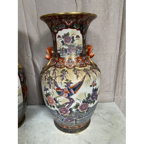 94 - A LARGE DECORATIVE PAIR OF IMARI VASES, with panels to front and reverse featuring birds amongst fol... 