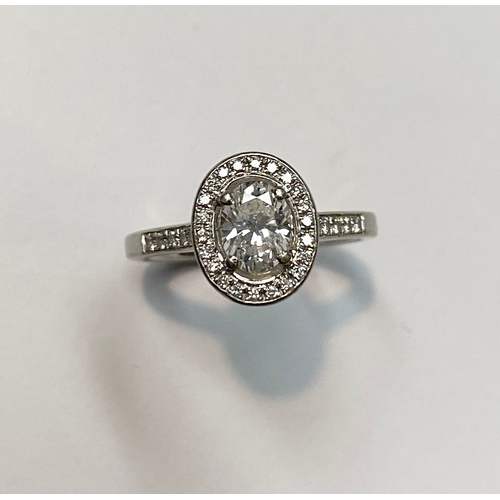 194 - AN EXCEPTIONAL PLATINUM OVAL SOLITAIRE DIAMOND RING, with central oval cut diamond surrounded by dia... 