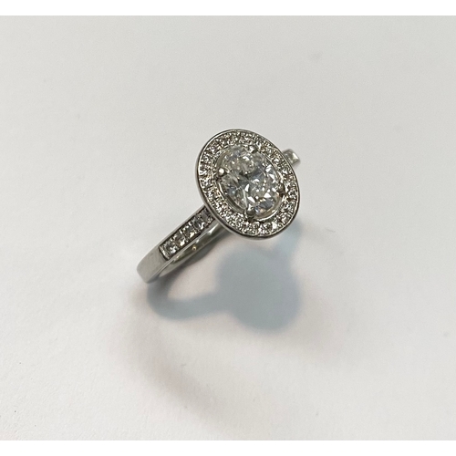 194 - AN EXCEPTIONAL PLATINUM OVAL SOLITAIRE DIAMOND RING, with central oval cut diamond surrounded by dia... 