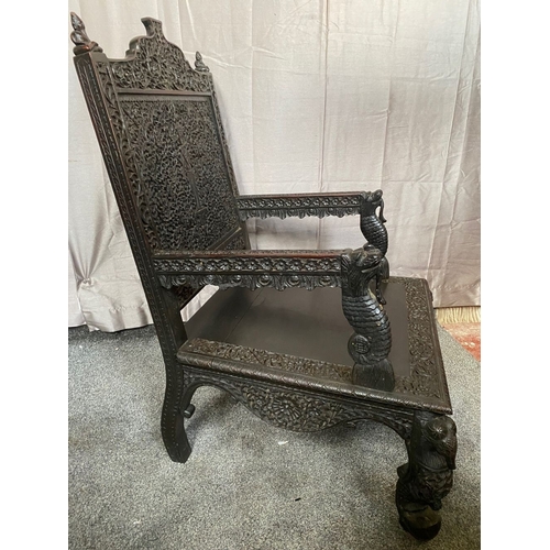 11 - AN IMPRESSIVE CARVED THRONE STYLE HARDWOOD CHAIR, decorated all over with scrolling foliage detail; ... 