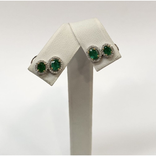 115 - A BEAUTIFUL PAIR OF HAND-AMDE 18CT WHITE GOLD EMERALD & DIAMOND EARRINGS, each with two oval cut eme... 