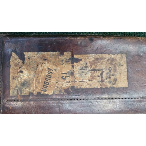 130 - A VINTAGE LEATHER HANDSTITCHED GUN CASE, with old travel labels attached, the interior could do with... 