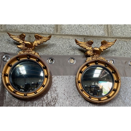 22 - A VERY GOOD PAIR OF GILT EAGLE MOUNTED CONVEX MIRRORS, each with a black reeded slip & impressive ea... 