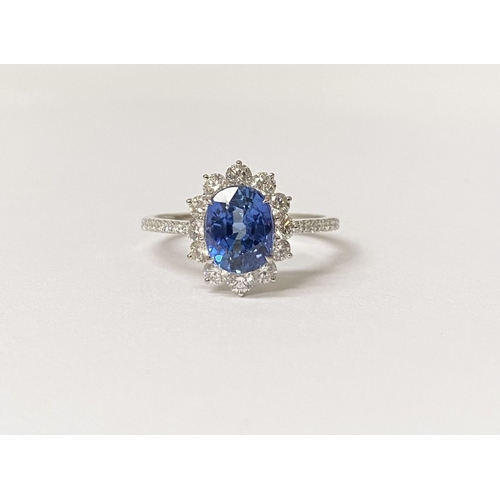 31 - AN 18CT WHITE GOLD CEYLON SAPPHIRE AND DIAMOND CLUSTER RING, with central vibrant Ceylon sapphire in... 