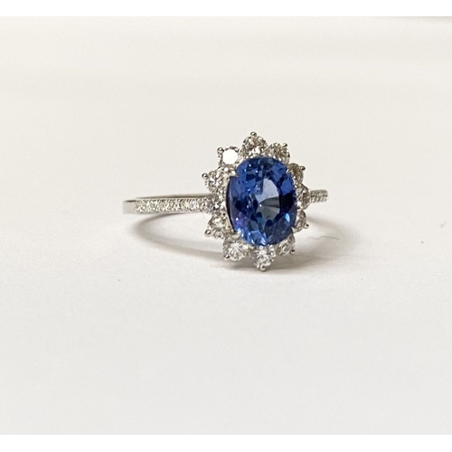 31 - AN 18CT WHITE GOLD CEYLON SAPPHIRE AND DIAMOND CLUSTER RING, with central vibrant Ceylon sapphire in... 