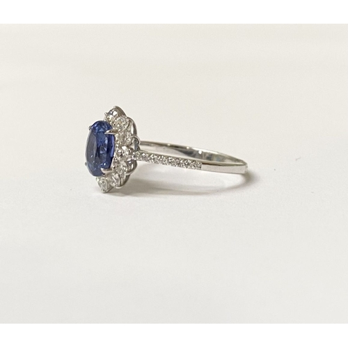 31 - AN 18CT WHITE GOLD CEYLON SAPPHIRE AND DIAMOND CLUSTER RING, with central vibrant Ceylon sapphire in... 