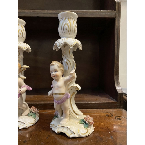 78 - THREE EARLY 20TH CENTURY GERMAN PORCELAIN CHERUB CANDLESTICKS, marked to base with blue mark featuri... 