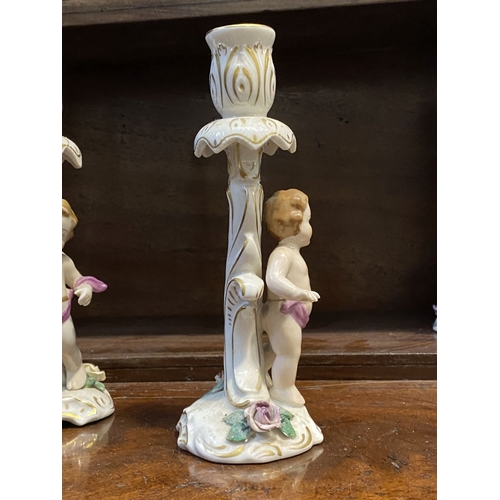 78 - THREE EARLY 20TH CENTURY GERMAN PORCELAIN CHERUB CANDLESTICKS, marked to base with blue mark featuri... 