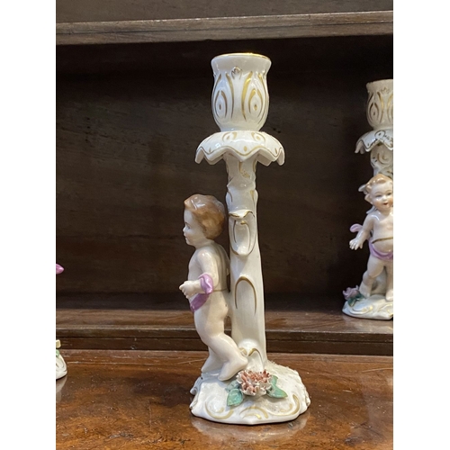 78 - THREE EARLY 20TH CENTURY GERMAN PORCELAIN CHERUB CANDLESTICKS, marked to base with blue mark featuri... 