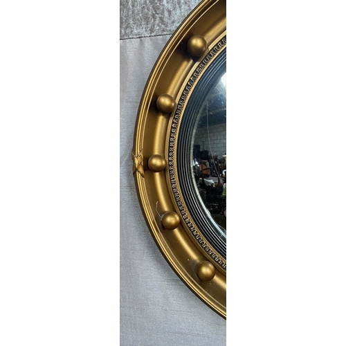 95 - A GOOD QUALITY GILT CONVEX WALL MIRROR – CIRCULAR, with regency style ball & ribbon design to the fr... 