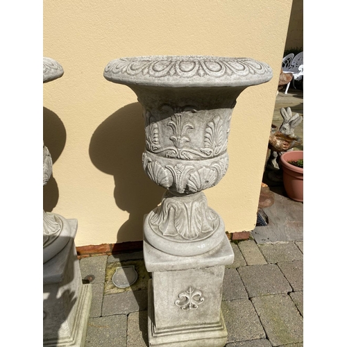 101 - AN EXCELLENT PAIR OF STONE GARDEN URNS, highly decorated with acanthus leaf design to body, standing... 