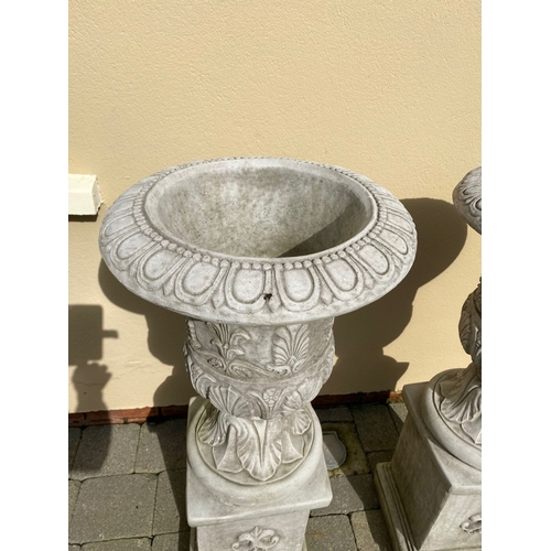 101 - AN EXCELLENT PAIR OF STONE GARDEN URNS, highly decorated with acanthus leaf design to body, standing... 