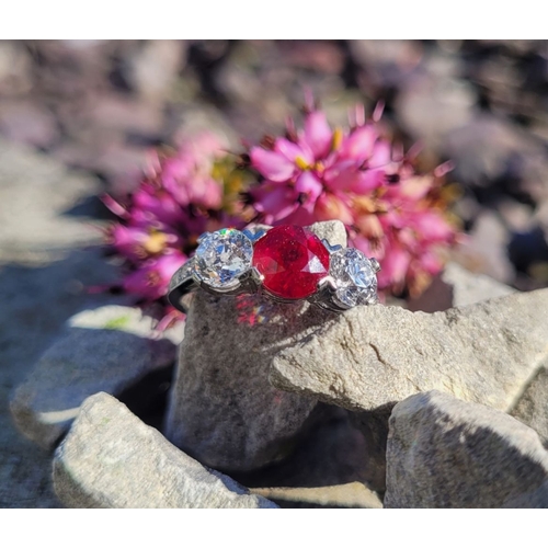 11 - A PRETTY THREE STONE DIAMOND & RUBY RING, the central ruby stone 1.65cts, flanked by a round cut dia... 