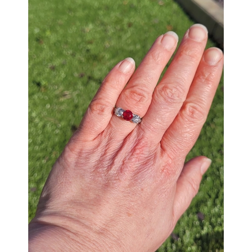 11 - A PRETTY THREE STONE DIAMOND & RUBY RING, the central ruby stone 1.65cts, flanked by a round cut dia... 