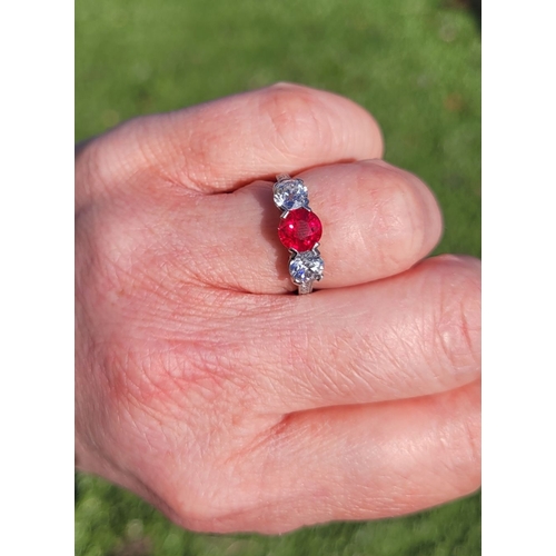 11 - A PRETTY THREE STONE DIAMOND & RUBY RING, the central ruby stone 1.65cts, flanked by a round cut dia... 