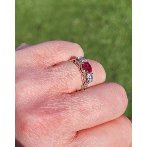 11 - A PRETTY THREE STONE DIAMOND & RUBY RING, the central ruby stone 1.65cts, flanked by a round cut dia... 