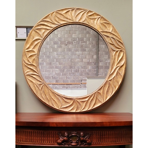 118 - A VERY GOOD QUALITY PORTA ROMANA GILT COLOURED CIRCULAR WALL MIRROR, with wave type design to the fr... 