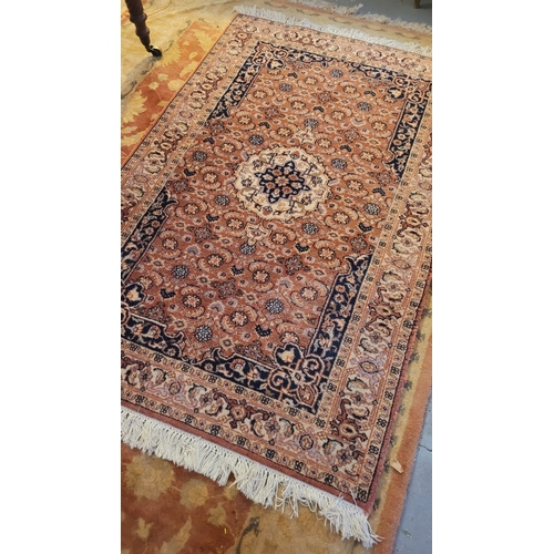 129 - A GOOD QUALITY TAPRIZ FLOOR RUG, with floral design, having a central medallion, and long fringe to ... 