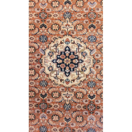 129 - A GOOD QUALITY TAPRIZ FLOOR RUG, with floral design, having a central medallion, and long fringe to ... 