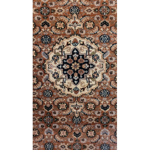 129 - A GOOD QUALITY TAPRIZ FLOOR RUG, with floral design, having a central medallion, and long fringe to ... 