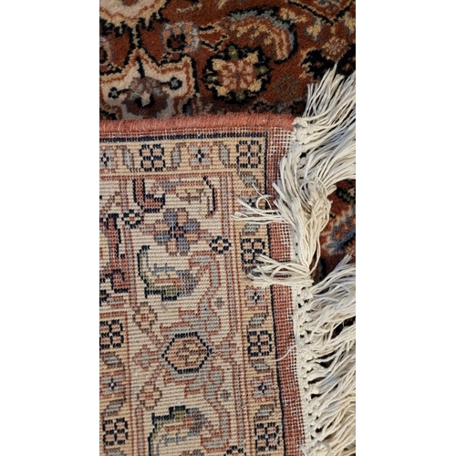 129 - A GOOD QUALITY TAPRIZ FLOOR RUG, with floral design, having a central medallion, and long fringe to ... 