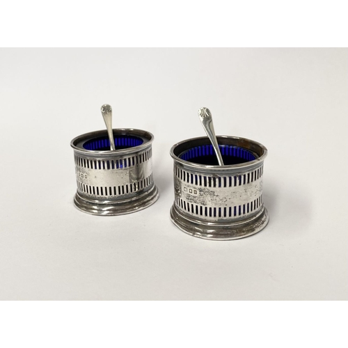 134 - A PAIR OF SILVER SALTS WITH SPOONS, the salts with blue glass liners and openwork design to body, on... 