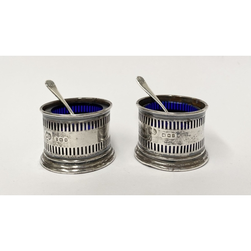 134 - A PAIR OF SILVER SALTS WITH SPOONS, the salts with blue glass liners and openwork design to body, on... 