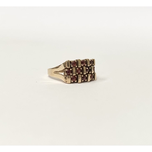 150 - A 9CT YELLOW GOLD THREE ROW GARNET COCKTAIL RING, featuring striking design with three rows of round... 