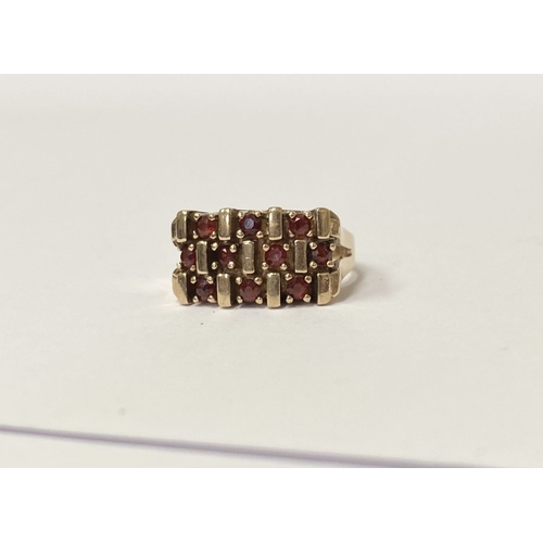 150 - A 9CT YELLOW GOLD THREE ROW GARNET COCKTAIL RING, featuring striking design with three rows of round... 