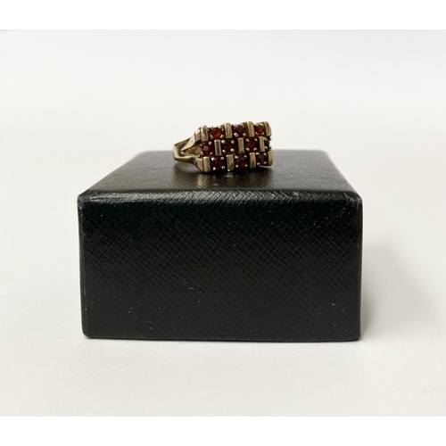 150 - A 9CT YELLOW GOLD THREE ROW GARNET COCKTAIL RING, featuring striking design with three rows of round... 