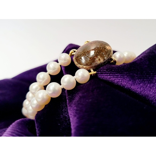 16 - A BEAUTIFUL DOUBLE ROW PEARL BRACELET WITH GEORGIAN GOLD CLAPS which holds a stone within it. The cl... 