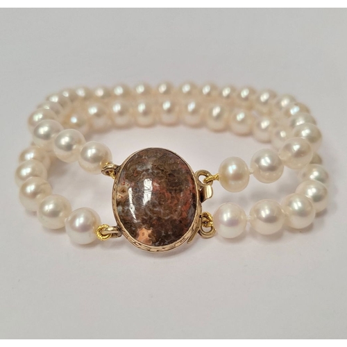 16 - A BEAUTIFUL DOUBLE ROW PEARL BRACELET WITH GEORGIAN GOLD CLAPS which holds a stone within it. The cl... 