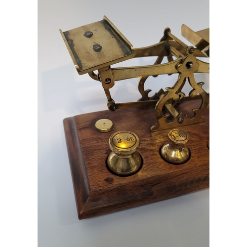 227 - A VINTAGE OAK & BRASS TABLE TOP SCALES, impressed ‘Warranted Accurate’ to the uprights. Comes with 5... 