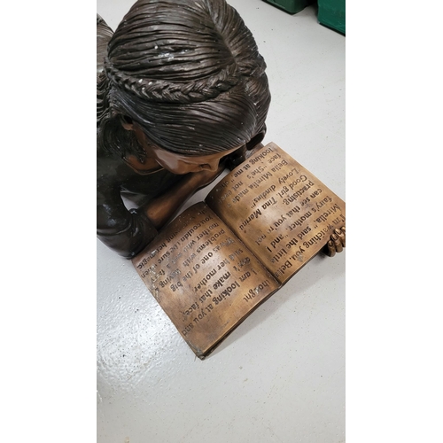 242 - A BRONZE GARDEN FIGURE, in the form of girl reading a book. 100cm long.